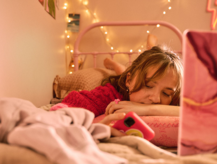 Fille regardant son téléphone dans sa chambre